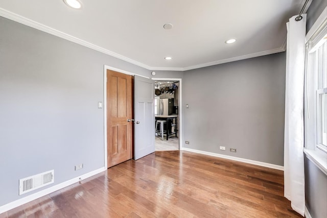 unfurnished bedroom featuring baseboards, wood finished floors, recessed lighting, and crown molding
