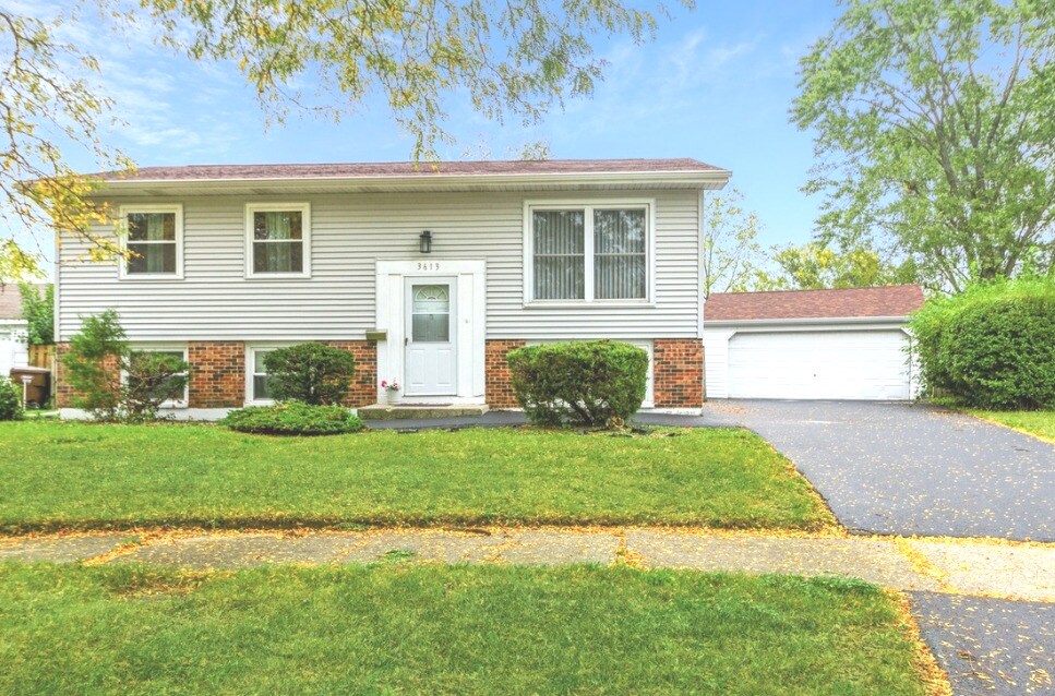 split foyer home featuring brick siding and a front yard