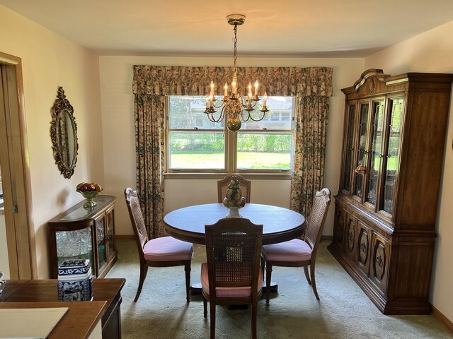 dining space with carpet flooring and a notable chandelier