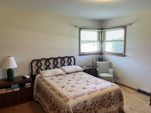 carpeted bedroom featuring visible vents and baseboards