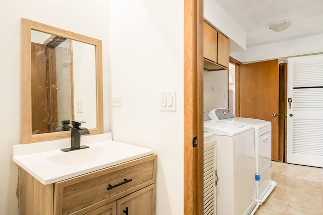 laundry room with cabinet space, light tile patterned floors, washing machine and dryer, and a sink