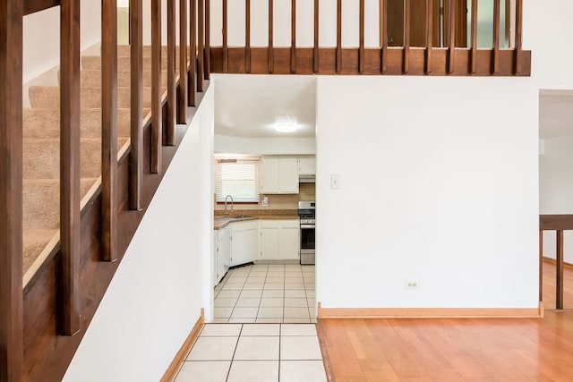 staircase featuring baseboards and wood finished floors