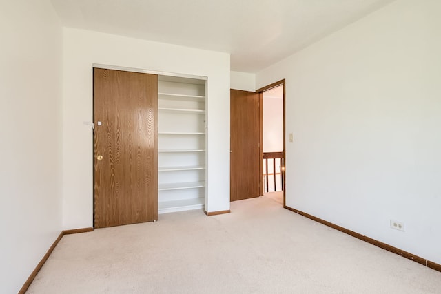 unfurnished bedroom with carpet flooring, baseboards, and a closet