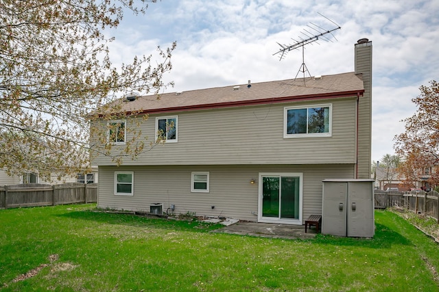 back of house with a fenced backyard, a patio, a chimney, and a yard