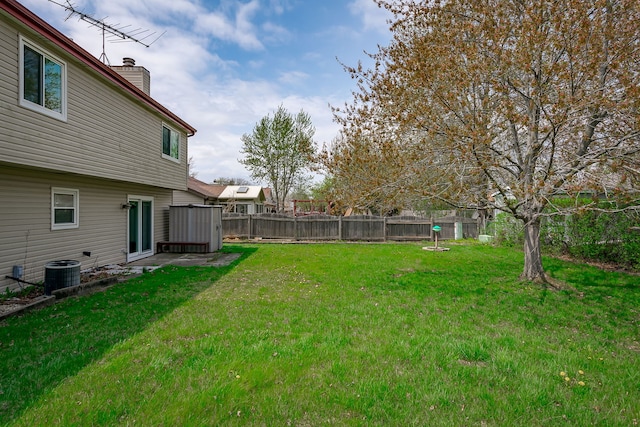view of yard with a fenced backyard and central AC