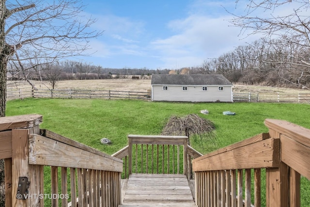 view of yard with a fenced backyard, a wooden deck, an outbuilding, and a rural view