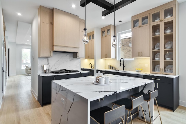 4014 N Kimball Ave, Chicago, IL 60618 - kitchen with a sink, gas cooktop, dark cabinetry, and a kitchen island