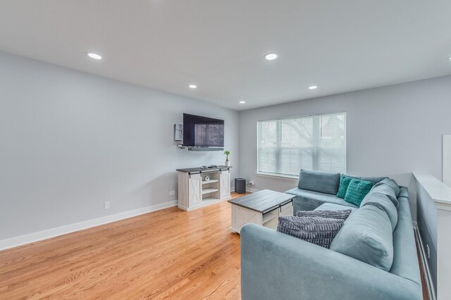 living room featuring baseboards, recessed lighting, and light wood-style flooring