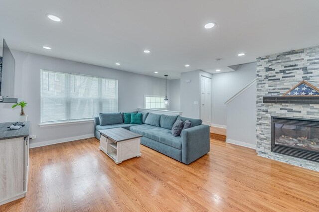 living room featuring baseboards, a healthy amount of sunlight, and light wood-type flooring