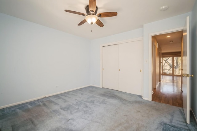 unfurnished bedroom with carpet flooring, a ceiling fan, baseboards, and a closet