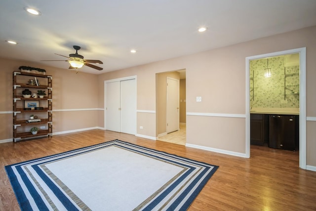 unfurnished bedroom with baseboards, a closet, light wood-style flooring, and connected bathroom