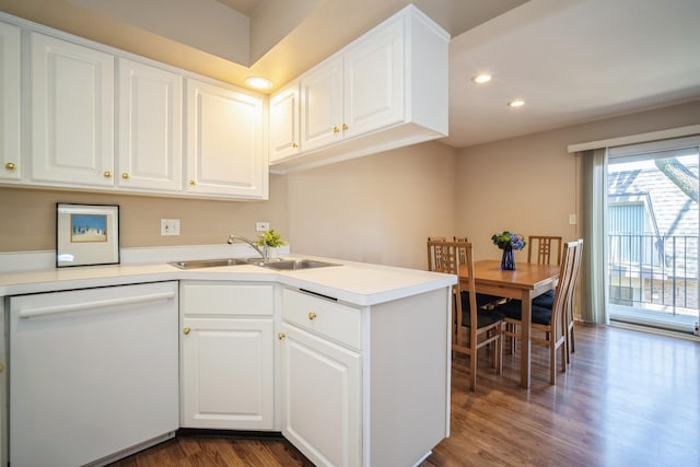 kitchen featuring white cabinets, white dishwasher, a sink, recessed lighting, and dark wood-type flooring