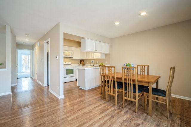 dining room with recessed lighting, baseboards, and light wood finished floors