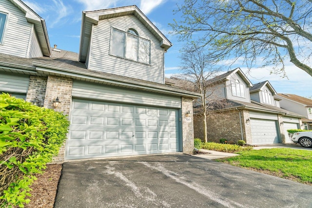 7017 Plymouth Ct, Tinley Park, IL 60477 - view of front of house with an attached garage, brick siding, and driveway