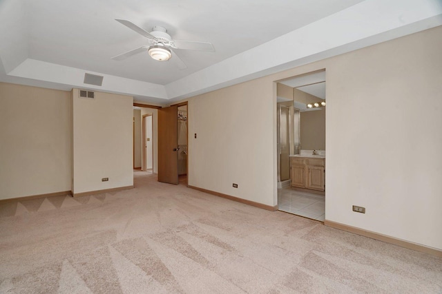 7017 Plymouth Ct, Tinley Park, IL 60477 - unfurnished bedroom featuring ensuite bathroom, visible vents, light carpet, a tray ceiling, and baseboards