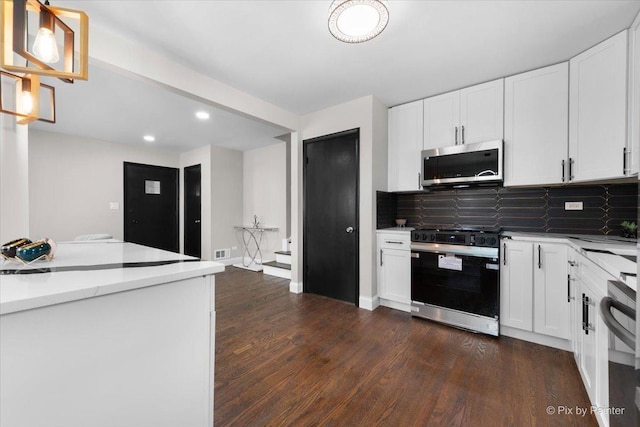 4430 Roslyn Rd, Downers Grove, IL 60515 - kitchen with dark wood finished floors, gas stove, stainless steel microwave, backsplash, and white cabinets