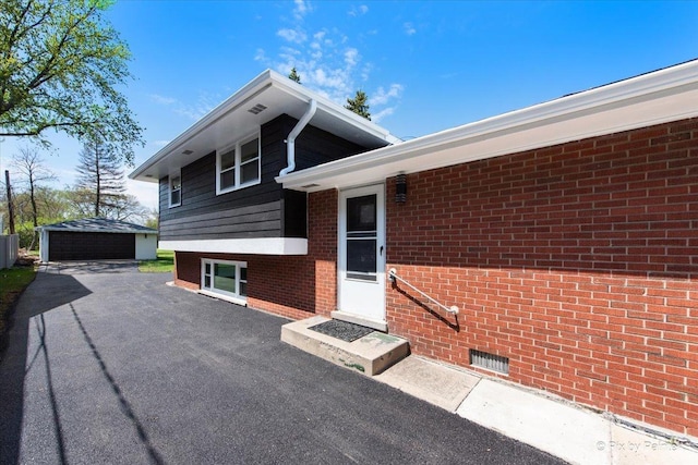 4430 Roslyn Rd, Downers Grove, IL 60515 - exterior space with an outdoor structure, a garage, and brick siding