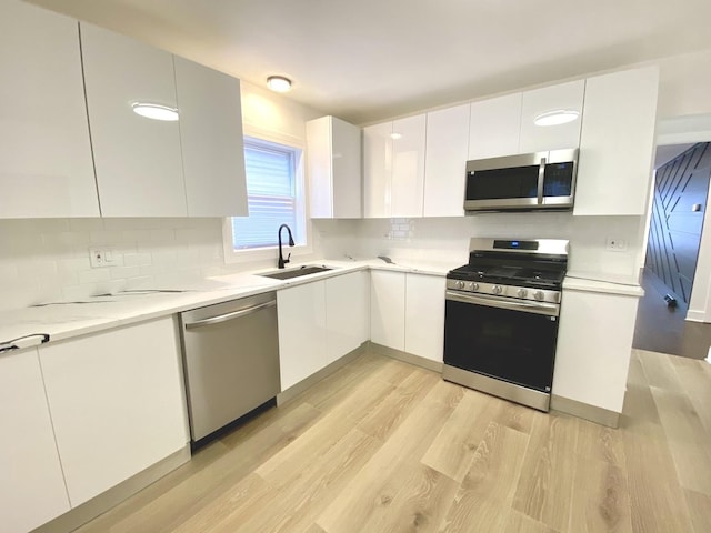 kitchen featuring appliances with stainless steel finishes, modern cabinets, and white cabinetry