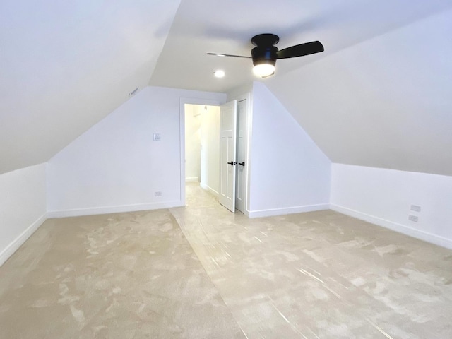 additional living space featuring baseboards, a ceiling fan, vaulted ceiling, and light carpet