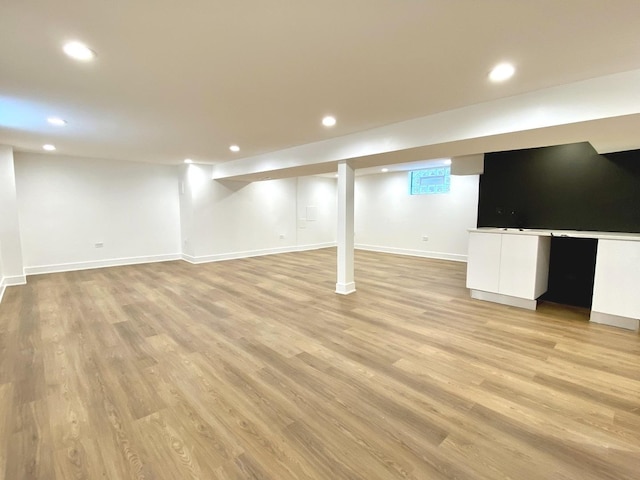 finished basement featuring recessed lighting, light wood-style flooring, and baseboards