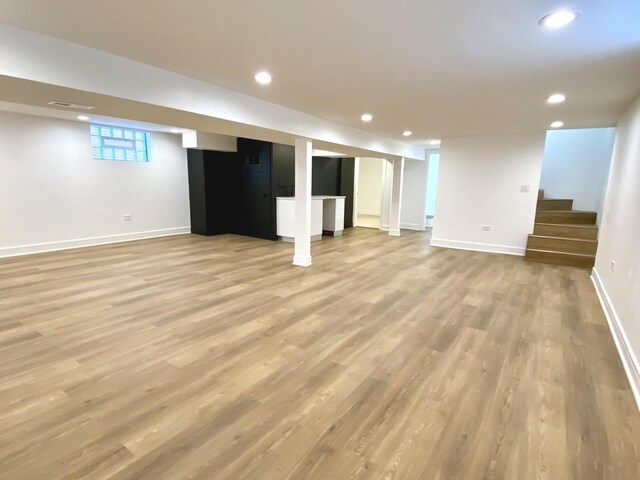 basement with recessed lighting, baseboards, wood finished floors, and stairway
