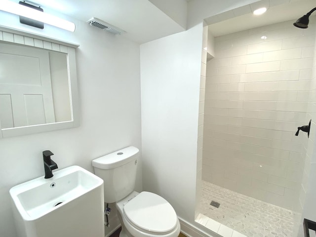 full bath featuring toilet, visible vents, a shower stall, and a sink