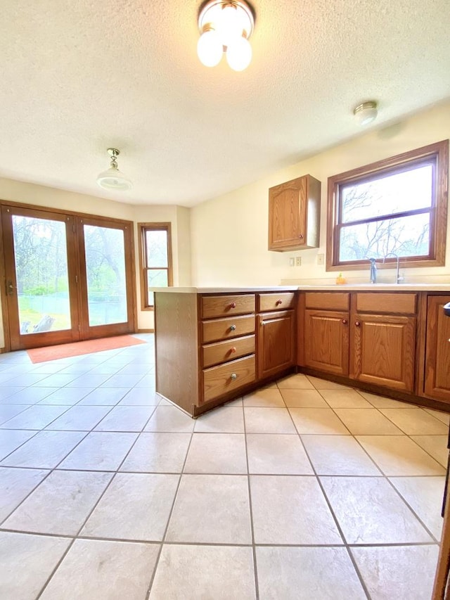 kitchen with light countertops, a textured ceiling, and a wealth of natural light