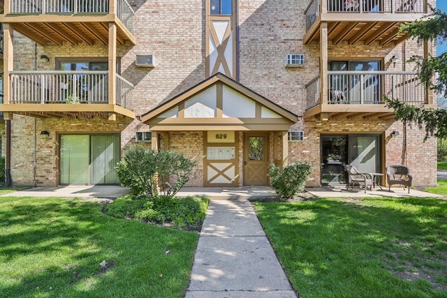 829 S Dwyer Ave Unit B, Arlington Heights, IL 60005 - view of exterior entry with a balcony, a yard, and brick siding