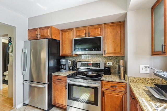 829 S Dwyer Ave Unit B, Arlington Heights, IL 60005 - kitchen with stainless steel appliances, backsplash, light stone counters, and brown cabinetry