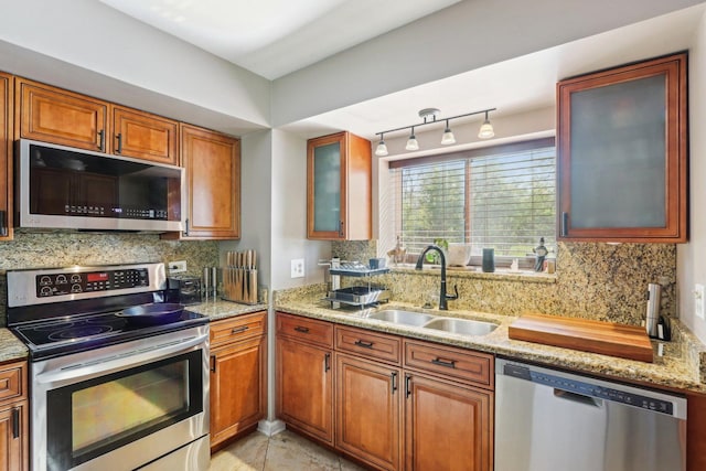 829 S Dwyer Ave Unit B, Arlington Heights, IL 60005 - kitchen featuring stainless steel appliances, a sink, brown cabinets, backsplash, and light stone counters