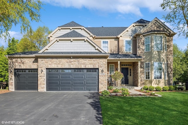 view of front facade with a garage, driveway, a front yard, and stone siding