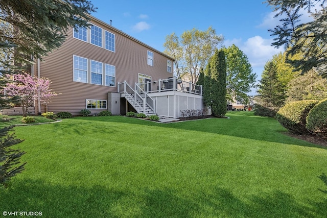 rear view of property featuring stairs, a yard, and a deck