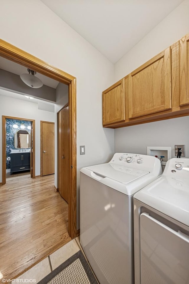washroom with cabinet space and separate washer and dryer