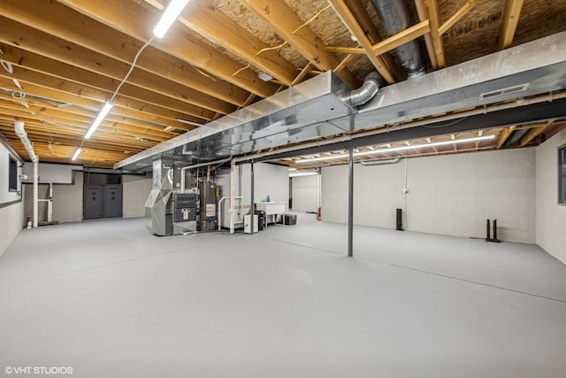 unfinished below grade area featuring heating unit, water heater, and a sink