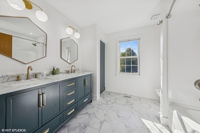 full bathroom featuring marble finish flooring, a shower, double vanity, toilet, and baseboards