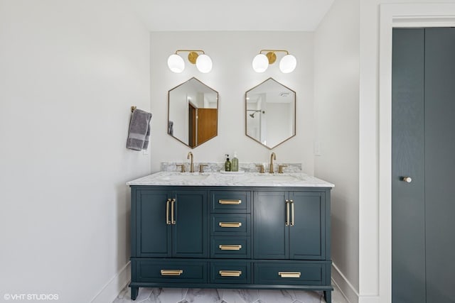 bathroom featuring baseboards, marble look tiles, and double vanity