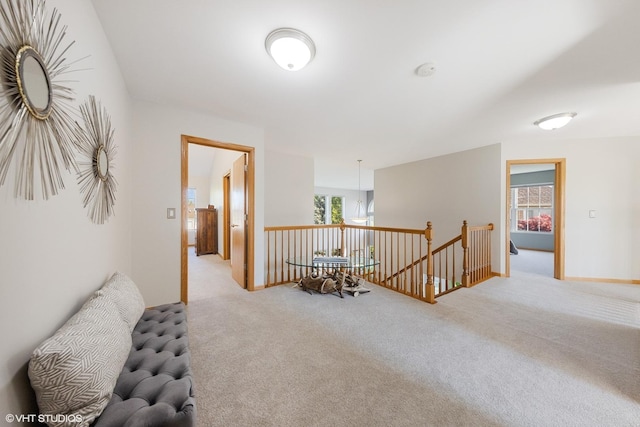 hallway featuring an upstairs landing, carpet floors, and healthy amount of natural light