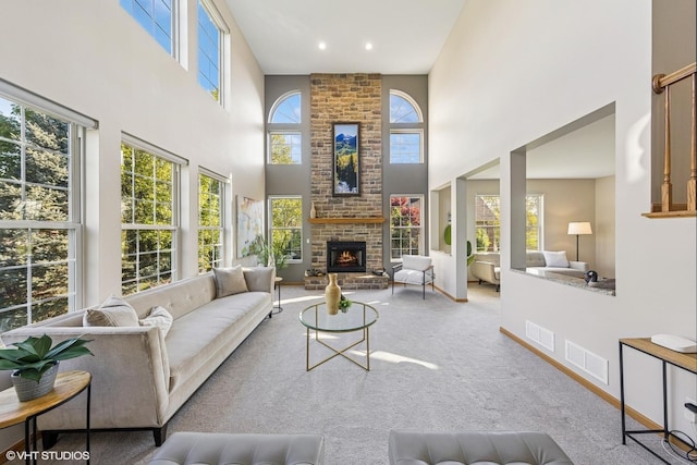 living area with a towering ceiling, carpet, a fireplace, and recessed lighting