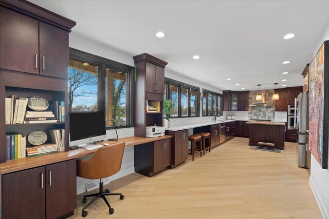 office space featuring recessed lighting, plenty of natural light, and built in desk