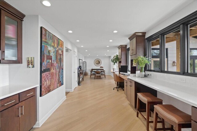 interior space featuring light wood-style floors, baseboards, recessed lighting, and built in study area