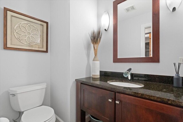 bathroom with visible vents, toilet, and vanity