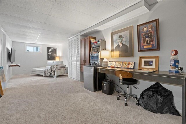 carpeted home office with a drop ceiling