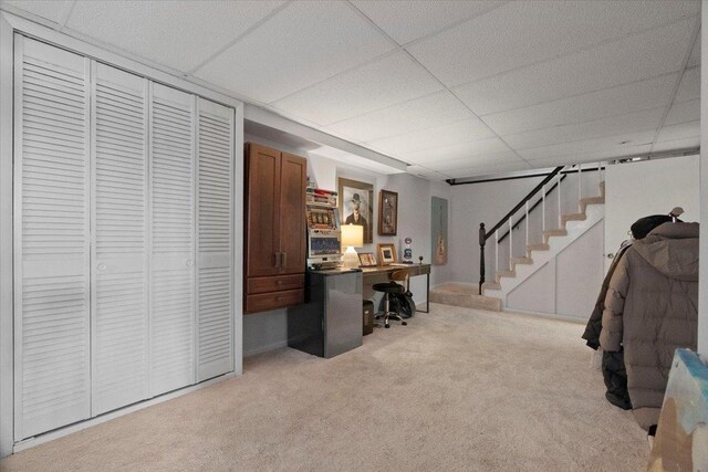 home office featuring light colored carpet and a paneled ceiling