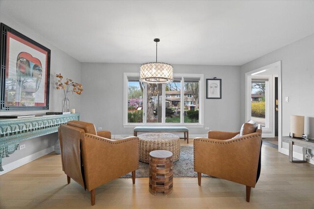 sitting room featuring baseboards, light wood-style flooring, and a healthy amount of sunlight