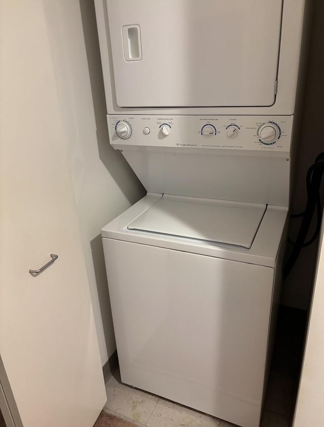 clothes washing area featuring laundry area and stacked washing maching and dryer