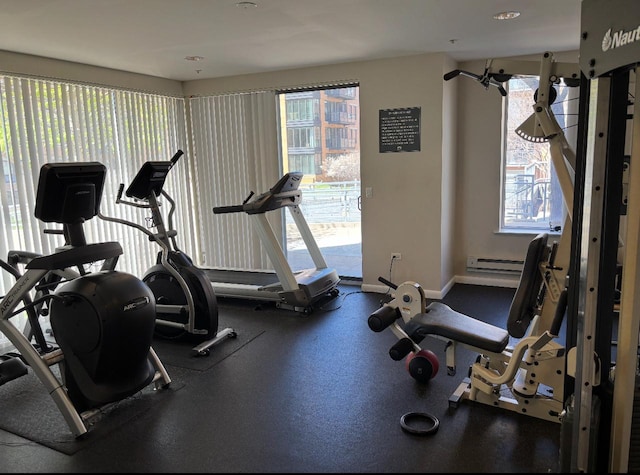 gym with baseboard heating, baseboards, and a wealth of natural light