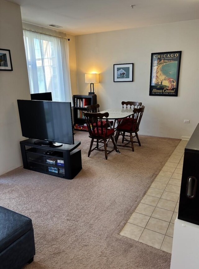 living room with light colored carpet, visible vents, and light tile patterned floors