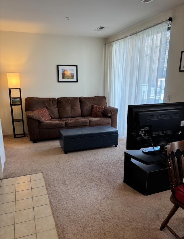 living area featuring visible vents and carpet