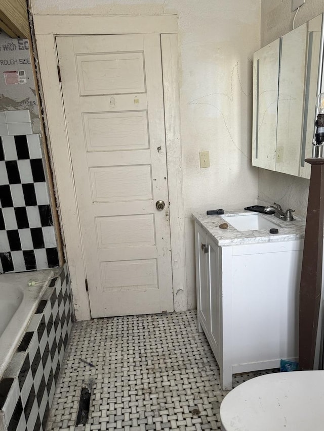 full bathroom with tiled bath, tile patterned floors, toilet, and vanity