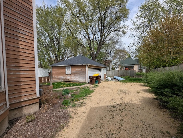 view of yard featuring fence, an outbuilding, and a detached garage